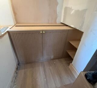 Wide view of built-in wine cabinet installation with side shelving in Woodford Green.