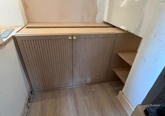 Wide view of built-in wine cabinet installation with side shelving in Woodford Green.