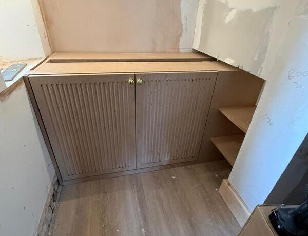 Wide view of built-in wine cabinet installation with side shelving in Woodford Green.