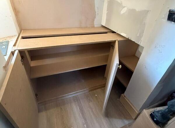 Open fitted cabinet showing internal shelf storage and side shelving unit.