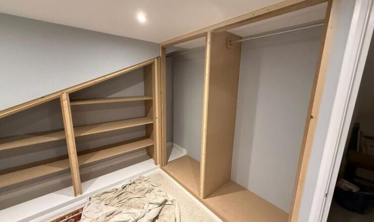 Loft storage installation with under-eaves bookshelf and wardrobe framing in Walthamstow.