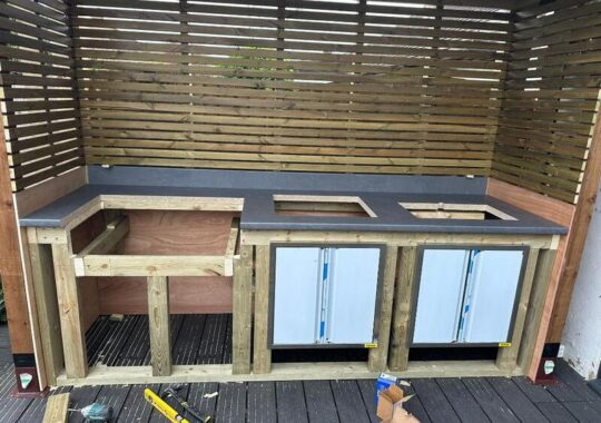 Outdoor cooking station with fitted countertop, storage bays, and appliance openings ready for installation.