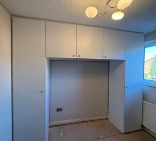 Completed fitted wardrobe with white doors and overhead cupboards in Chingford E4.