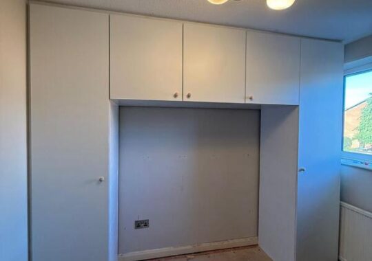 Completed fitted wardrobe with white doors and overhead cupboards in Chingford E4.