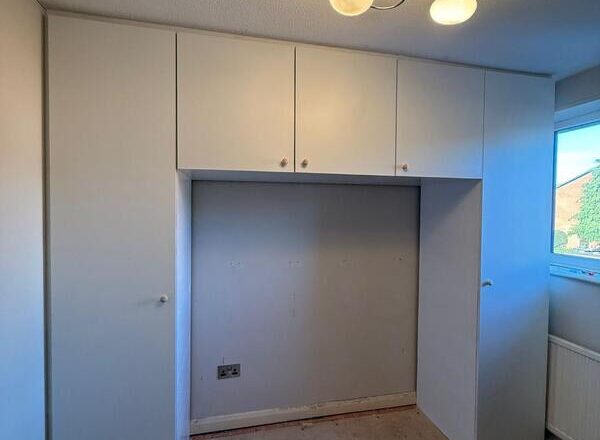 Completed fitted wardrobe with white doors and overhead cupboards in Chingford E4.