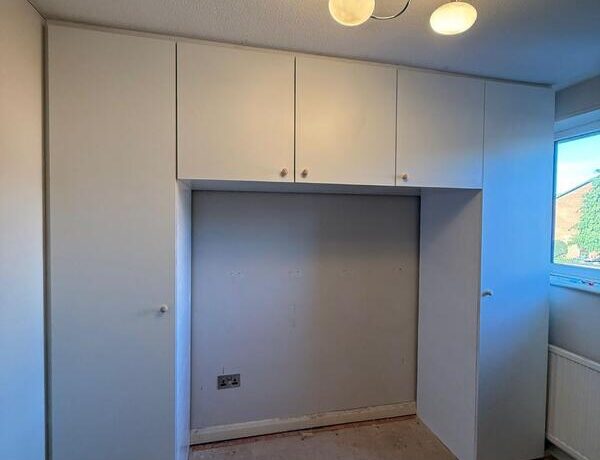 Completed fitted wardrobe with white doors and overhead cupboards in Chingford E4.