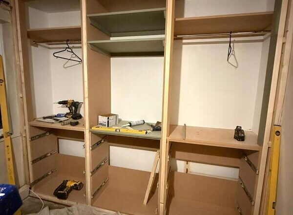 Built-in wardrobe internal layout with hanging rails and shelving installed