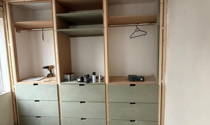 Fitted wardrobe with multiple base drawers and upper storage sections.
