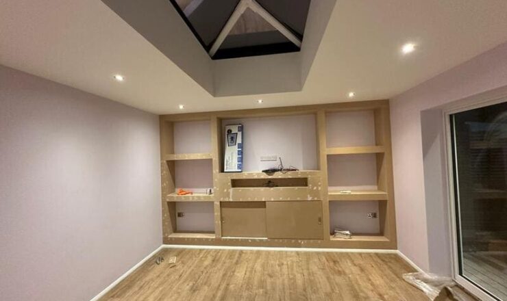 Completed media wall structure with symmetrical shelving and TV recess in a modern living space.