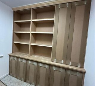 Completed built-in bookshelf cabinet with tall cupboard and cornice, ready for painting.