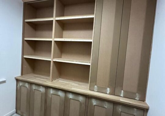 Completed built-in bookshelf cabinet with tall cupboard and cornice, ready for painting.