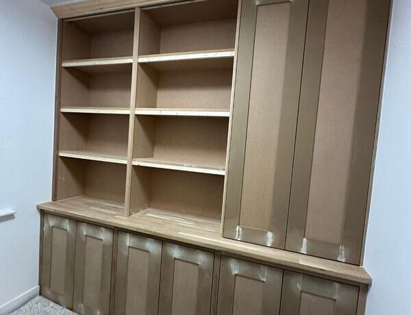 Completed built-in bookshelf cabinet with tall cupboard and cornice, ready for painting.