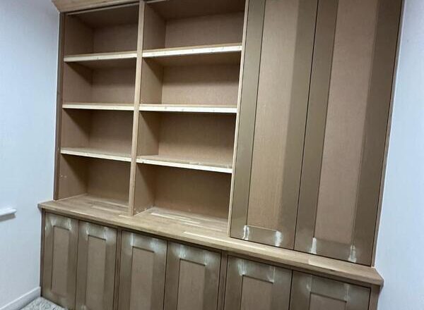 Completed built-in bookshelf cabinet with tall cupboard and cornice, ready for painting.