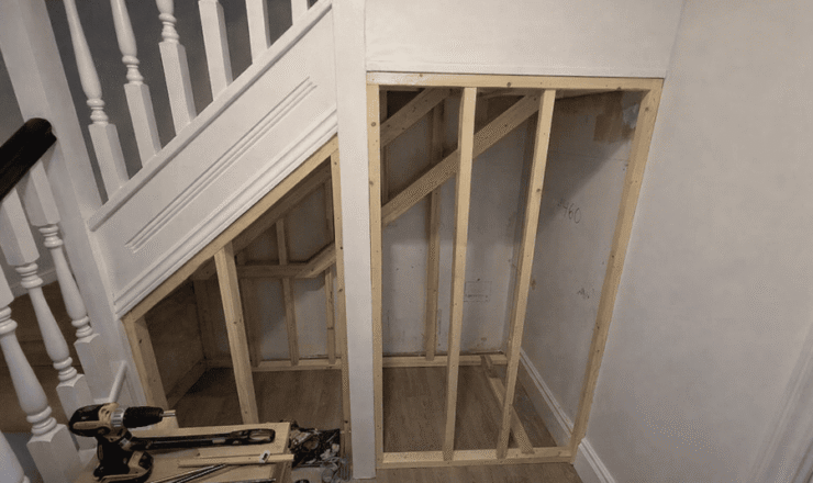 Under-stairs cupboard framing installed with timber studwork in a hallway in Buckhurst Hill.