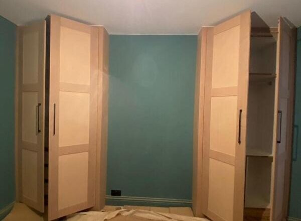 Installed fitted wardrobe in Loughton with shaker doors, black handles, and internal hanging/shelving.