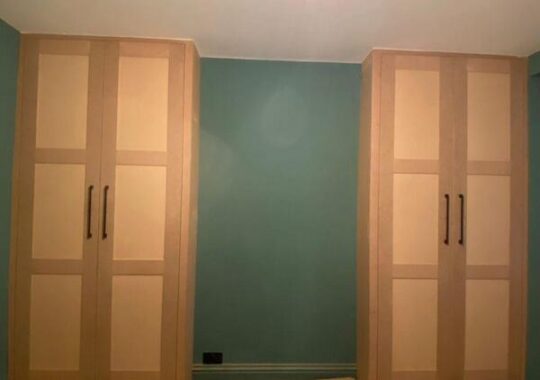 Pair of matching fitted wardrobes installed either side of wall in Loughton with modern shaker finish.
