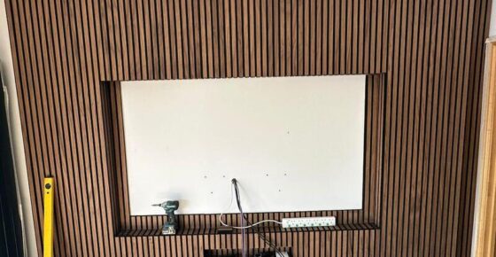 Close-up of vertical slatted media wall finish around recessed TV opening.