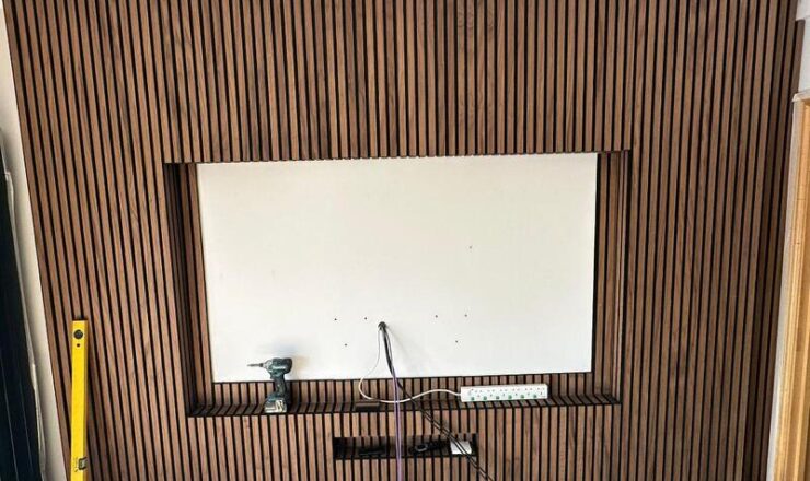 Close-up of vertical slatted media wall finish around recessed TV opening.
