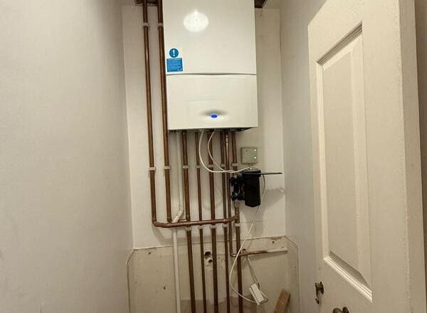 Boiler installed with exposed copper pipework before boxing in and cabinet build.