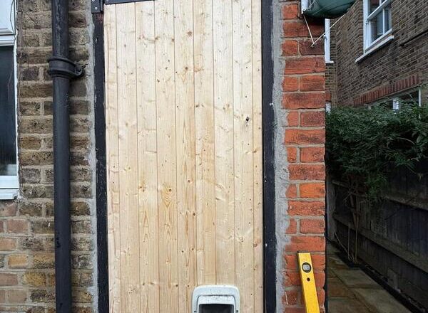 Timber back door with fitted cat flap and traditional hardware, newly installed.